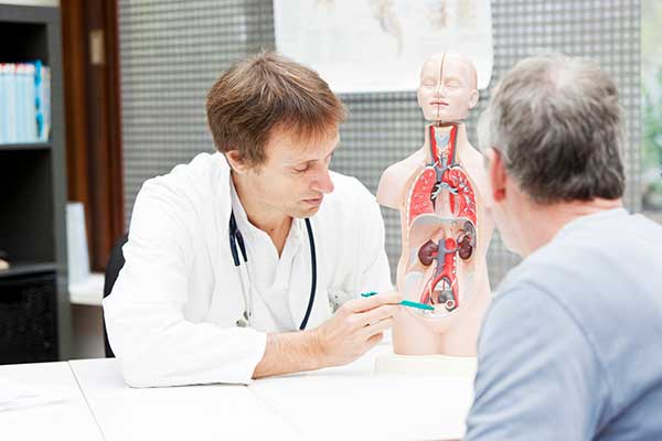 Doctor showing patient how a prostate exam is done