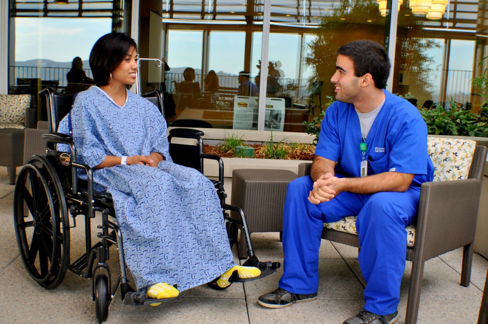 Picture 007 (1) male nurse helping female patient in a wheel chair having a conversation